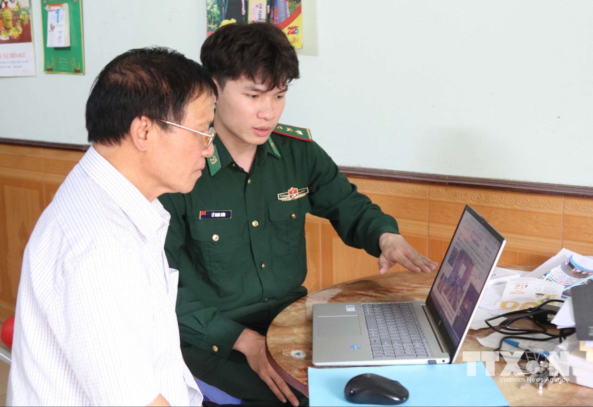 Cán bộ Đồn Biên phòng cửa khẩu Chi Ma chỉ dẫn người dân nhận biết các website thông tin chính thống. (Ảnh: Quang Duy/TTXVN)